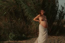 Photographe antibes grossesse - femme enceinte debout avec voile autour des hanches et nue