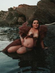Photographe grossesse Cannes - femme enceinte assise bord de l'eau avec robe en tulle marron