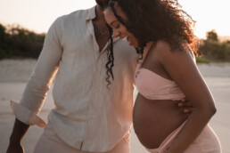 maternity photoshoot sint maarten couple laughing at the beach