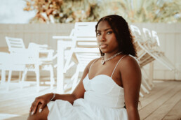 portrait photographer sint maarten woman sitting pool deck with palm trees and natural light