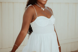 seance portrait femme saint martin robe blanche debout et grand sourire avec lumiere naturelle